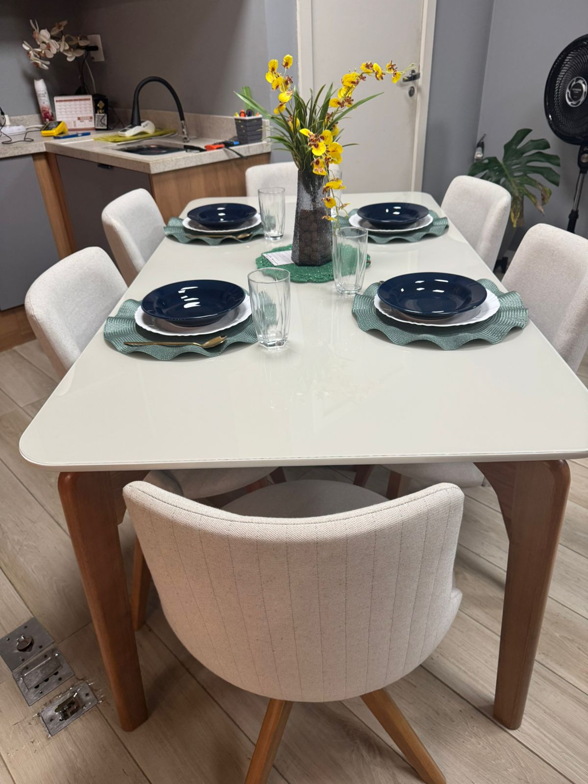 Mesa de jantar branca posta com cadeiras estofadas